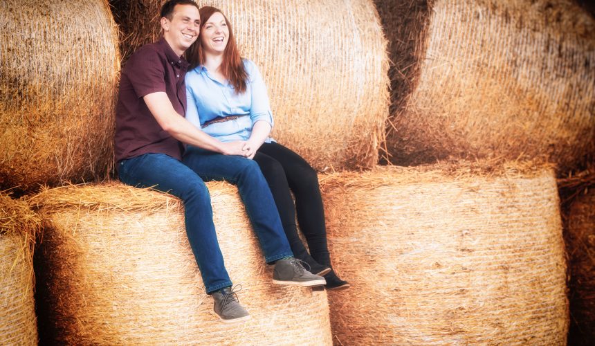 sweet couple sitting on hay bales